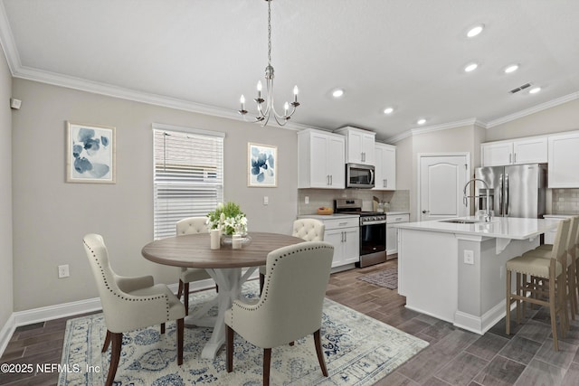 dining area with crown molding, sink, and a notable chandelier