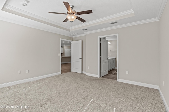 unfurnished bedroom featuring a tray ceiling and carpet floors