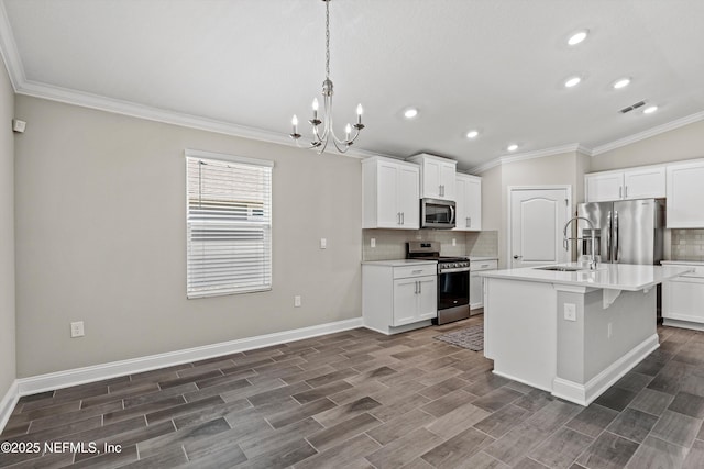 kitchen featuring sink, a center island with sink, appliances with stainless steel finishes, pendant lighting, and white cabinets