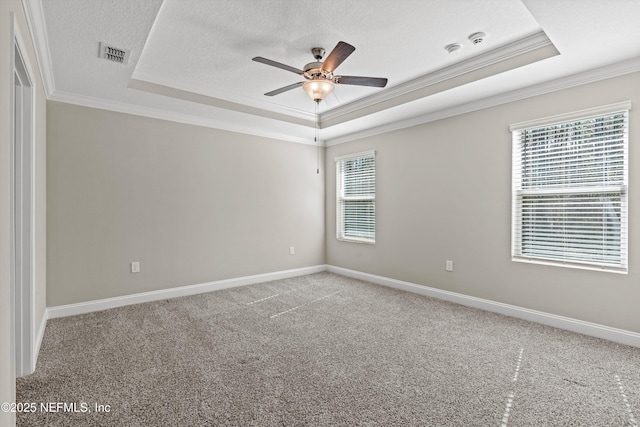 unfurnished room featuring ceiling fan, ornamental molding, a raised ceiling, and a textured ceiling