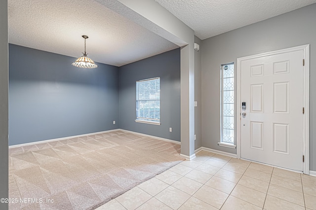 carpeted foyer entrance featuring an inviting chandelier and a textured ceiling