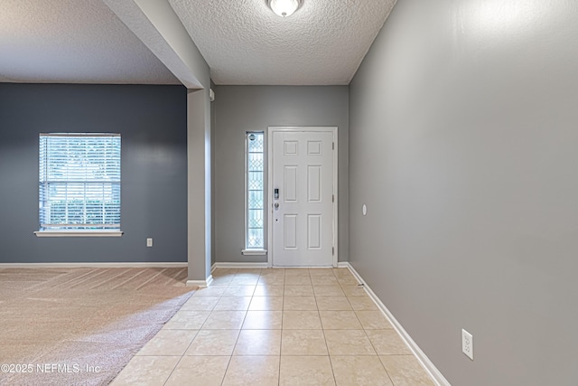 tiled entrance foyer with plenty of natural light and a textured ceiling