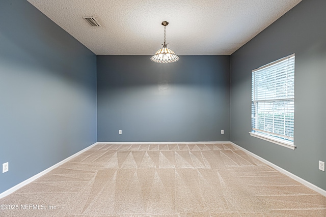 carpeted spare room with a textured ceiling