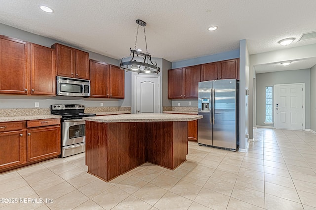 kitchen featuring appliances with stainless steel finishes, decorative light fixtures, a center island, and light tile patterned floors