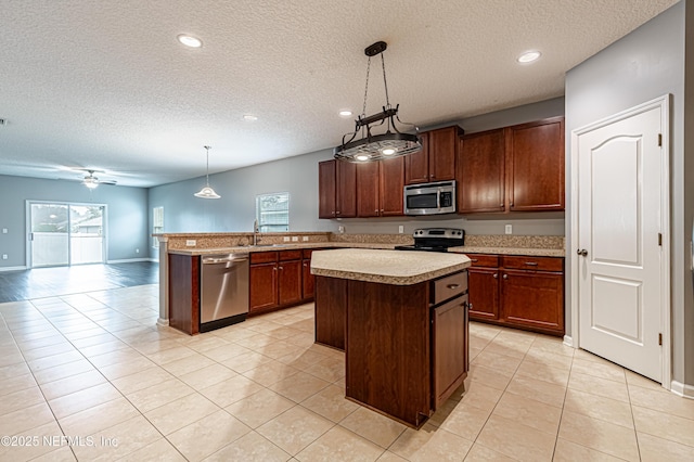 kitchen featuring stainless steel appliances, sink, a center island, and pendant lighting