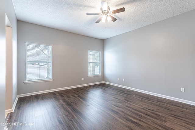 unfurnished room featuring dark wood-type flooring, a wealth of natural light, a textured ceiling, and ceiling fan