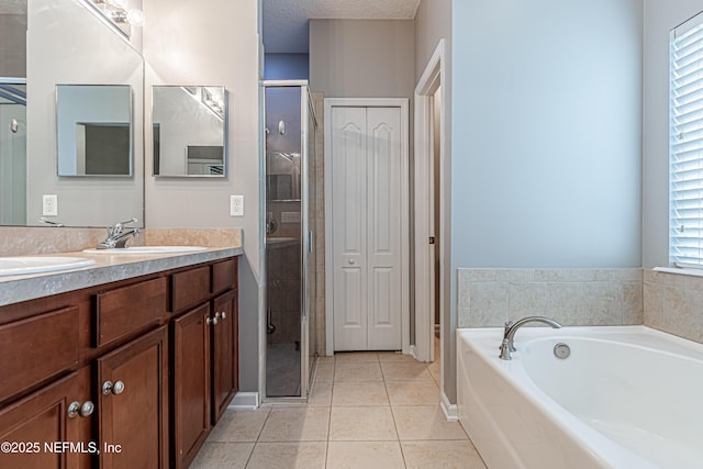 bathroom with tile patterned floors, separate shower and tub, a textured ceiling, and vanity