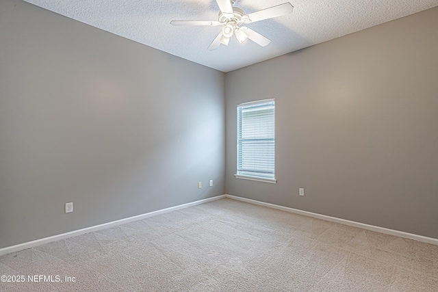 empty room with light colored carpet, a textured ceiling, and ceiling fan