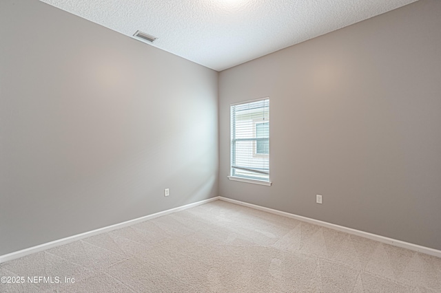 carpeted empty room with a textured ceiling