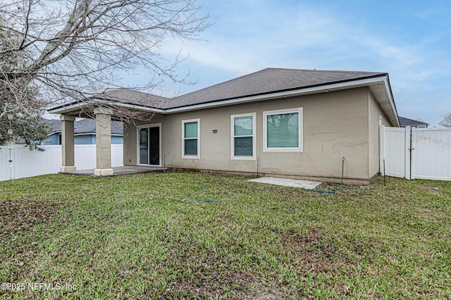 rear view of property with a patio and a lawn