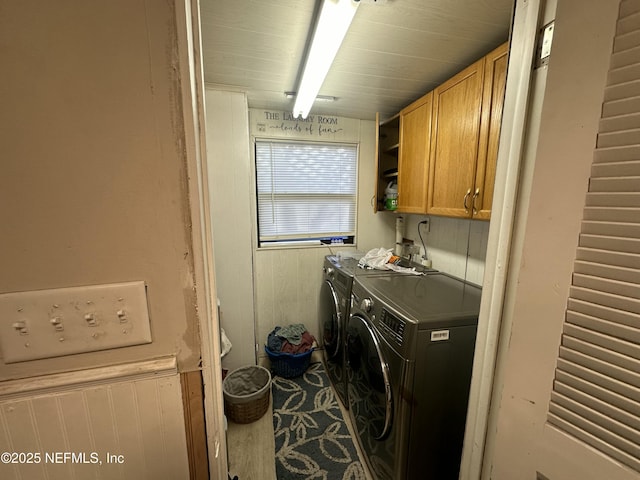 laundry room with washer and dryer and cabinets