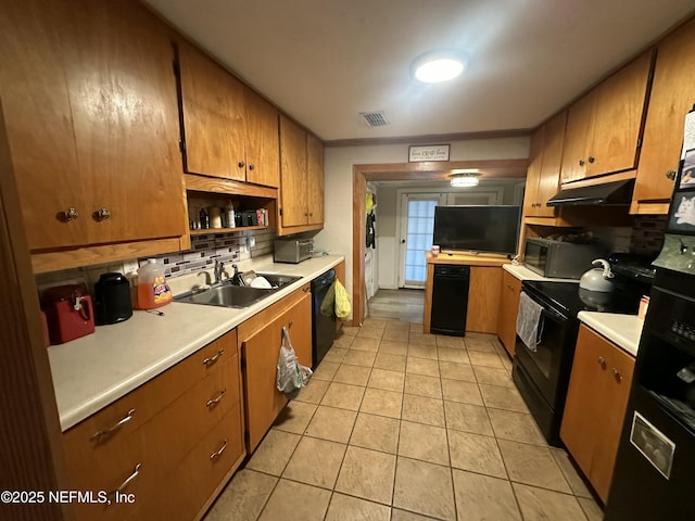 kitchen featuring sink, light tile patterned floors, backsplash, and black appliances