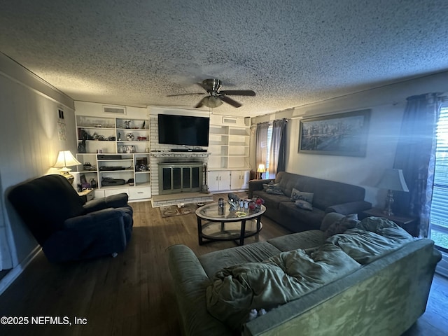 living room featuring a brick fireplace, hardwood / wood-style flooring, plenty of natural light, and a textured ceiling