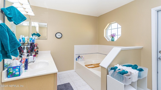 bathroom with tile patterned flooring, a garden tub, vanity, and baseboards