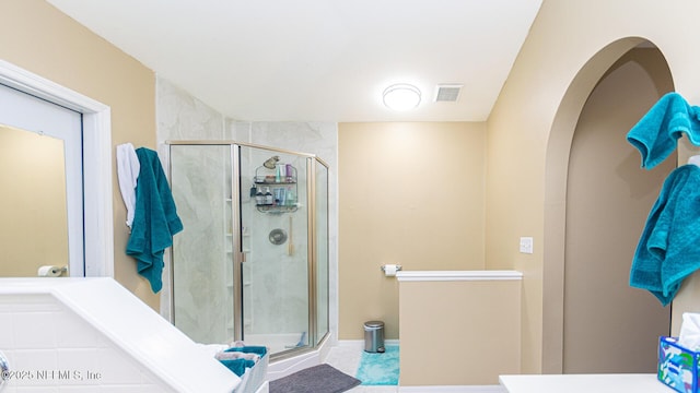 bathroom with a shower stall and visible vents