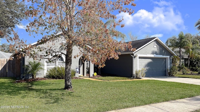 view of front of home with a garage, concrete driveway, stucco siding, fence, and a front yard