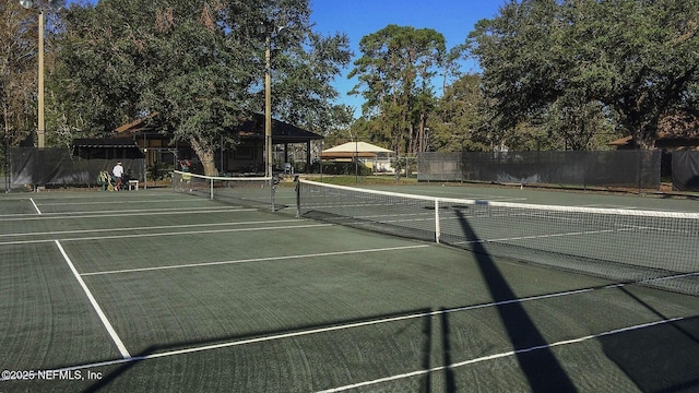 view of tennis court featuring fence