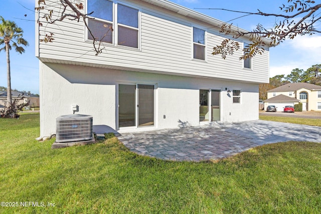 back of property featuring central AC unit, a yard, and a patio area