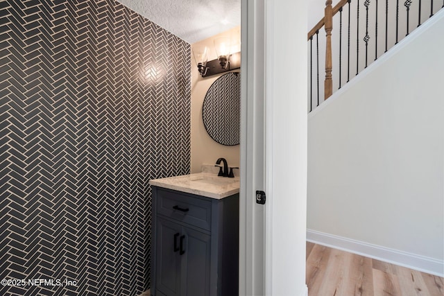 bathroom with vanity, hardwood / wood-style floors, a textured ceiling, and tile walls