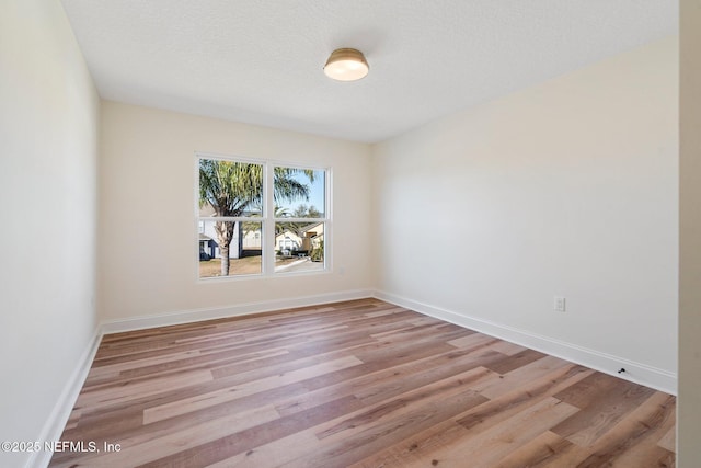 spare room with light hardwood / wood-style flooring and a textured ceiling