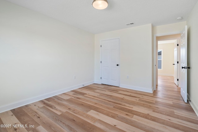 unfurnished bedroom with a textured ceiling and light wood-type flooring