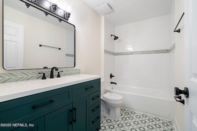 full bathroom with vanity, tiled shower / bath combo, toilet, and a textured ceiling