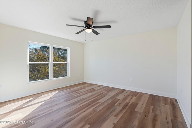 empty room featuring ceiling fan, wood-type flooring, and a textured ceiling