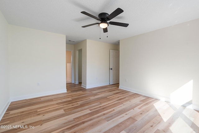 spare room with ceiling fan, light hardwood / wood-style flooring, and a textured ceiling