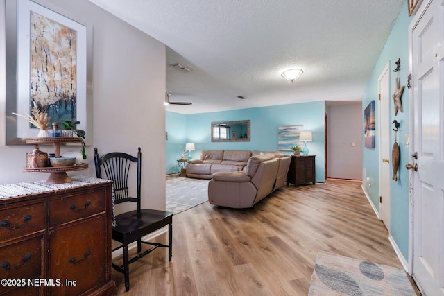 living room featuring light hardwood / wood-style floors and a textured ceiling