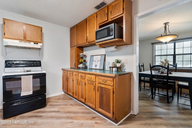 kitchen with decorative light fixtures, range with electric cooktop, a textured ceiling, and light wood-type flooring