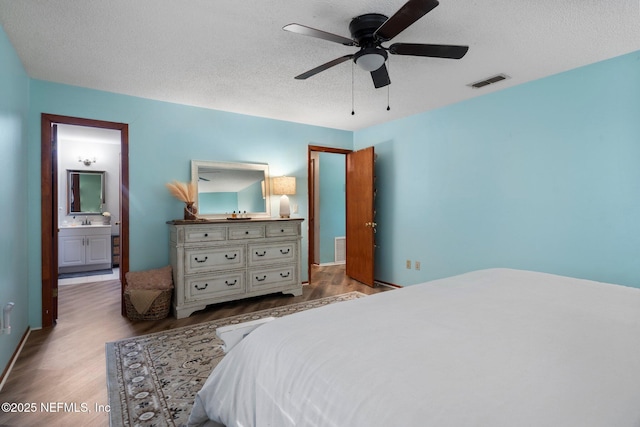 bedroom featuring ceiling fan, a textured ceiling, and light wood-type flooring