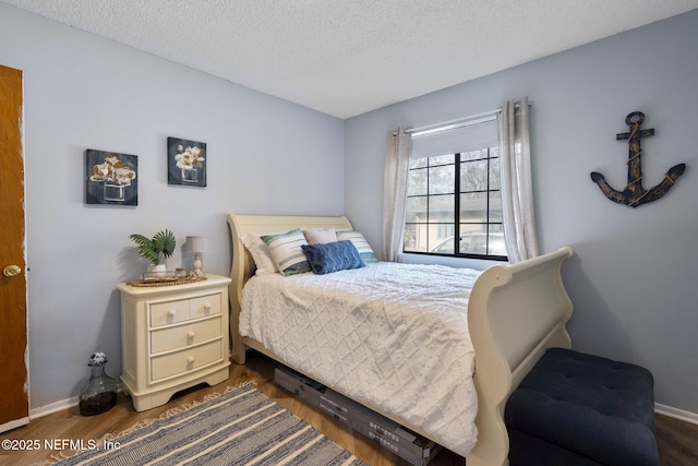 bedroom featuring dark wood-type flooring and a textured ceiling