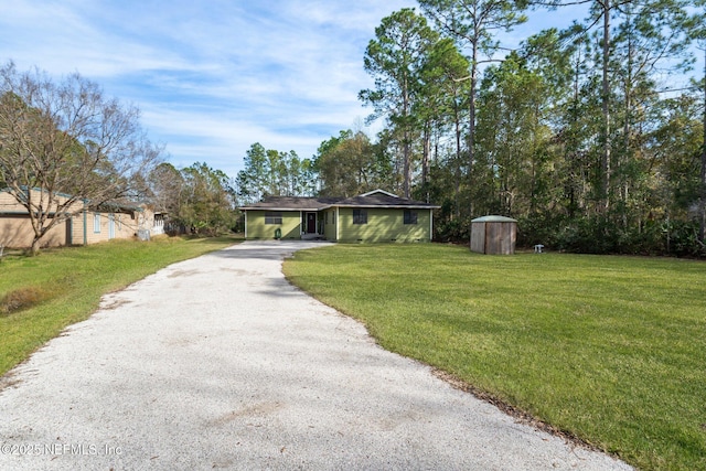 ranch-style house with a shed and a front lawn