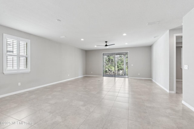 tiled empty room featuring a textured ceiling and ceiling fan