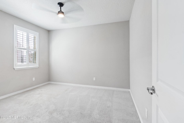 empty room with a textured ceiling, light colored carpet, and ceiling fan