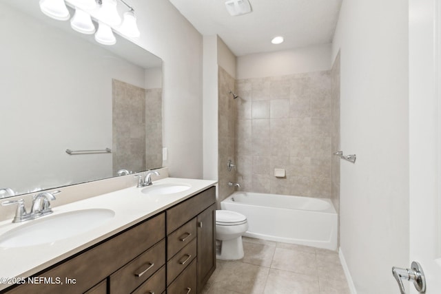 full bathroom featuring tile patterned flooring, tiled shower / bath, vanity, and toilet