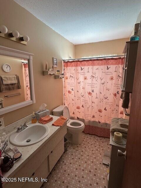 bathroom featuring sink, a textured ceiling, and toilet