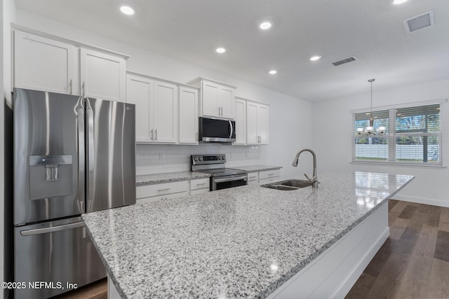 kitchen featuring white cabinetry, appliances with stainless steel finishes, sink, and a center island with sink