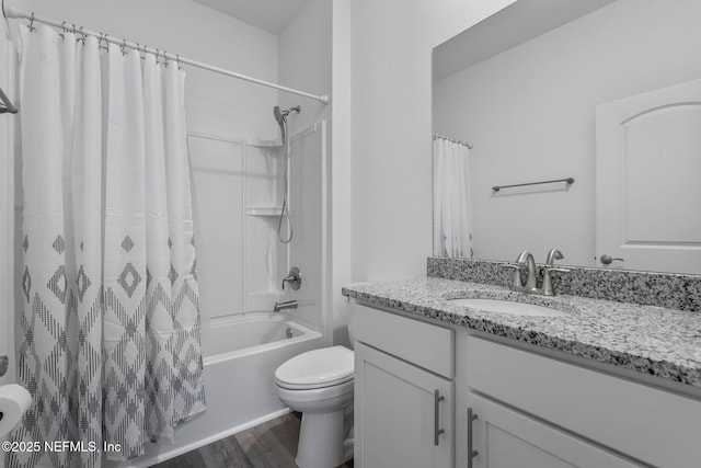 full bathroom featuring vanity, toilet, hardwood / wood-style floors, and shower / bath combo with shower curtain