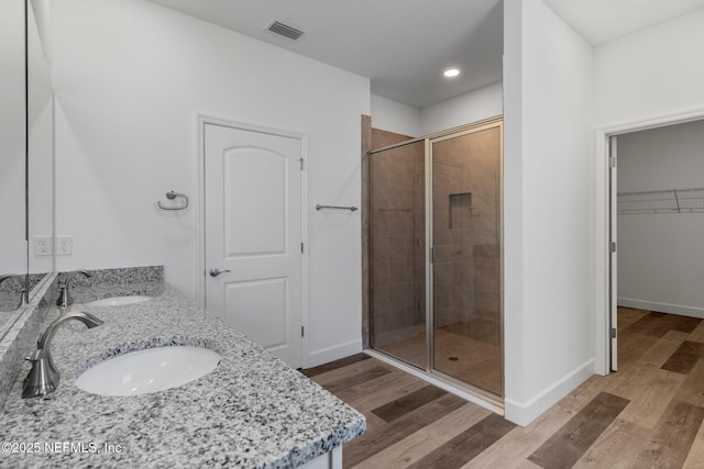 bathroom featuring walk in shower, wood-type flooring, and vanity