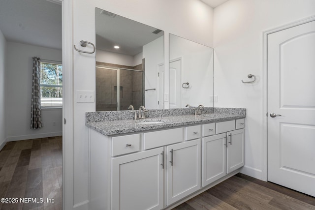 bathroom featuring vanity, a shower with shower door, and hardwood / wood-style floors