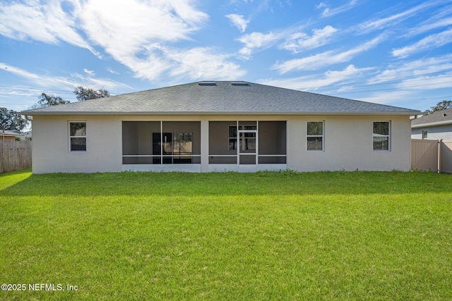 rear view of house with a yard and a sunroom