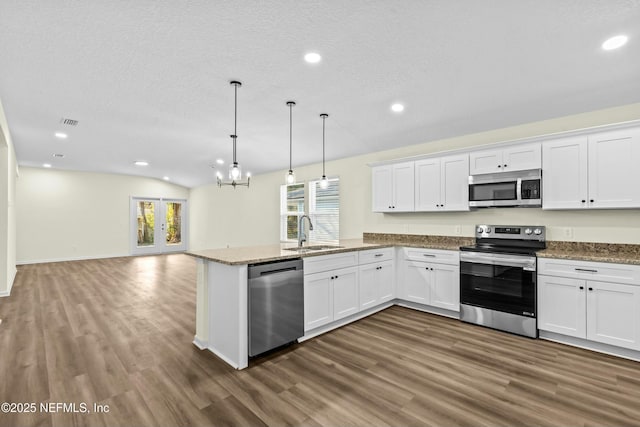 kitchen with sink, decorative light fixtures, white cabinets, and appliances with stainless steel finishes