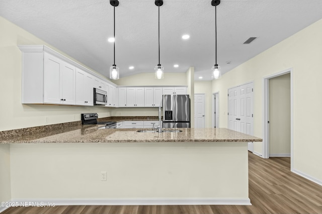 kitchen with white cabinetry, decorative light fixtures, appliances with stainless steel finishes, kitchen peninsula, and light stone countertops