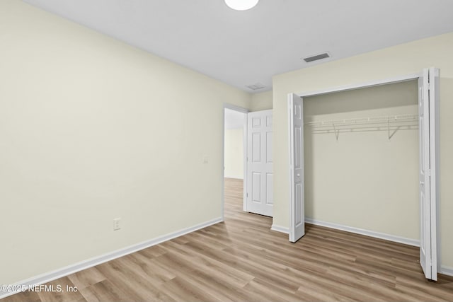 unfurnished bedroom with a closet and light wood-type flooring