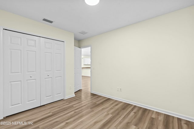 unfurnished bedroom with light hardwood / wood-style floors and a closet