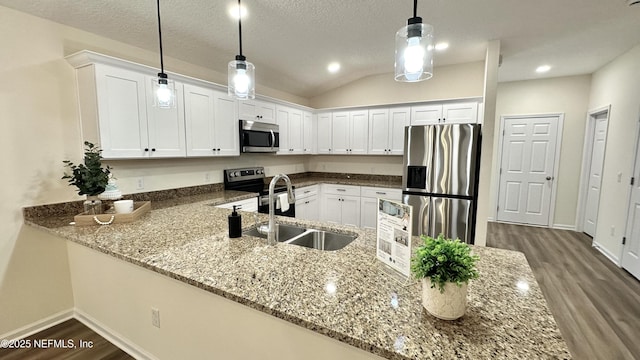 711 N Pine Ave, Green Cove Springs, FL 32043 - kitchen featuring a sink, a peninsula, stainless steel appliances, dark wood-style flooring, and white cabinetry