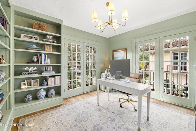 office with hardwood / wood-style flooring, a chandelier, and french doors