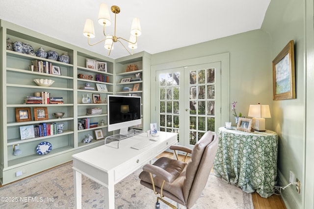 office area featuring a notable chandelier, hardwood / wood-style flooring, french doors, and built in shelves