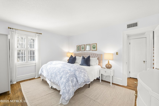 bedroom featuring wood-type flooring and a textured ceiling